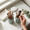 Sage green makeup brush holder on a marble vanity