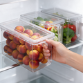 A hand pulls a clear fridge storage drawer by its handle