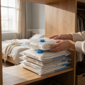 Hands stack flat vacuum storage bags on a wardrobe shelf
