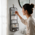 A woman takes a bottle from a hanging toiletry bag