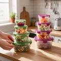 Hands close the lid of a clear food storage container